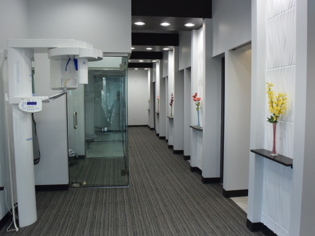 Modern hallway and glass treatment rooms at Space City Smiles
