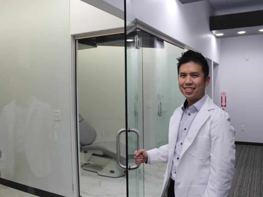 Dr. Johnathan Phan welcoming you into a treatment room at Space City Smiles